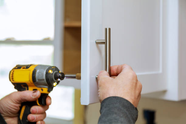istock The worker sets a new handle on the white cabinet with a screwdriver 876642168