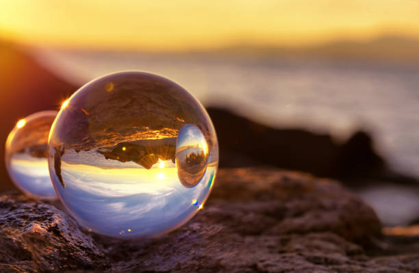 reflet de la boule de cristal sur le bord de la mer à la lumière de l’aube - photos de fauteuil sphérique photos et images de collection