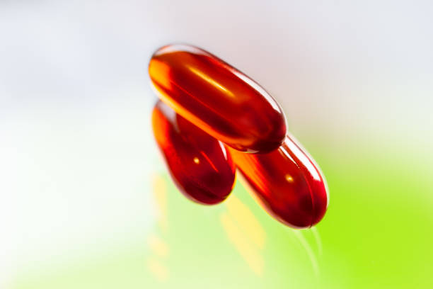 cápsulas transparentes rojo - capsule vitamin pill red lecithin fotografías e imágenes de stock