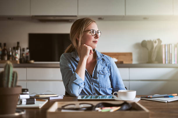 istock Young woman deep in thought while working from home 876649354