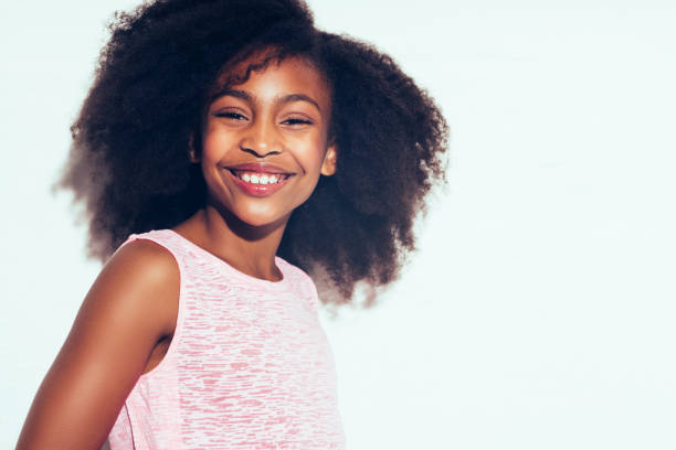 istock Smiling young African teen standing against a white background 876652500