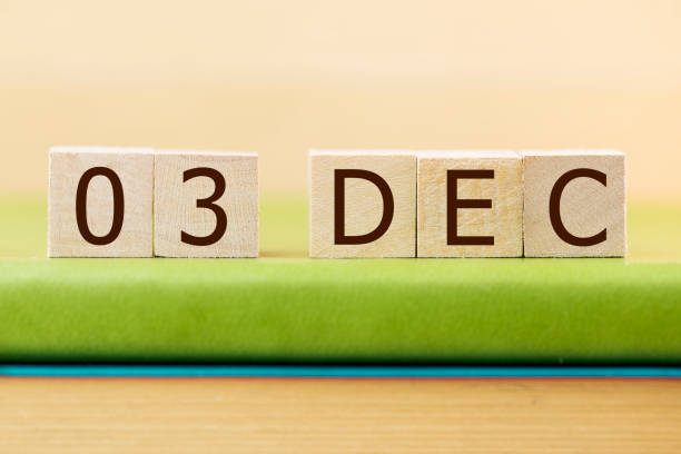 istock Wooden cube shape calendar for DEC 3 on green book, table. 876653392