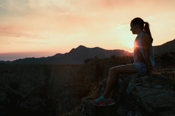 istock Girl looking at sunset on mountain 876655920