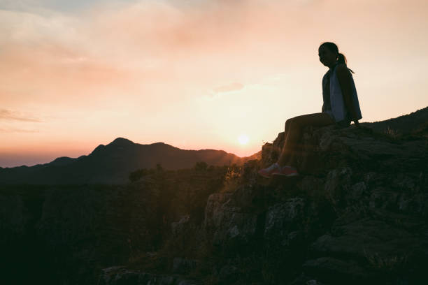 istock Girl looking at sunset on mountain 876656066