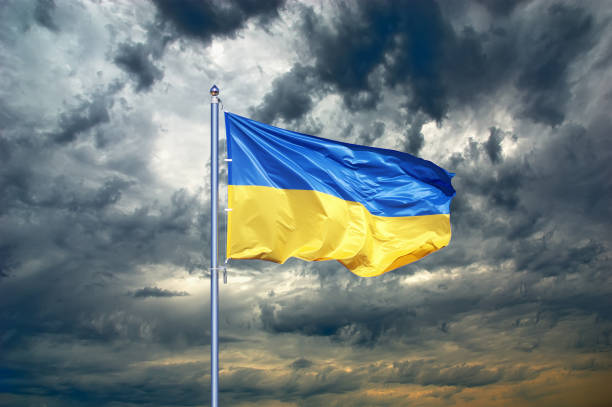 ukraine flag. ukrainian flag on black storm cloud sky. stormy weather - ucrânia imagens e fotografias de stock