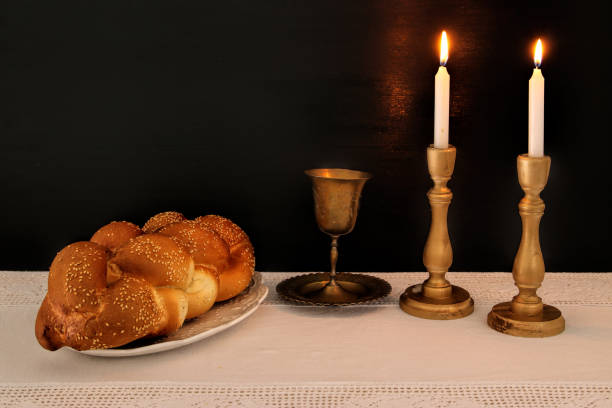 istock shabbat image. challah bread, shabbat wine and candles on the table. 876659894