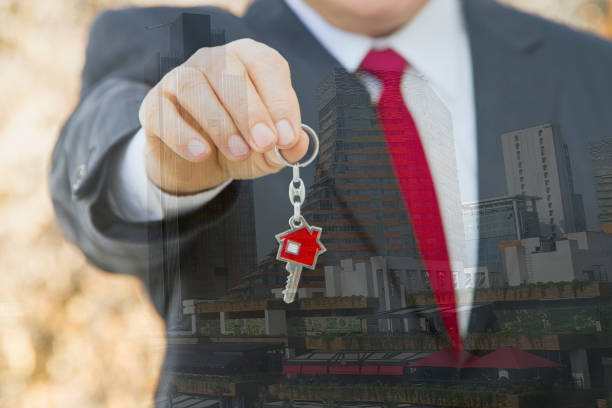 istock Businessman holding new home key. 876663858