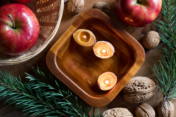 istock Christmas decoration - apples, pine branches, walnuts and floating candles, top view 876664314