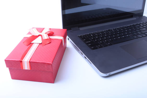 istock Laptop and christmas gifts box on white desk 876664320