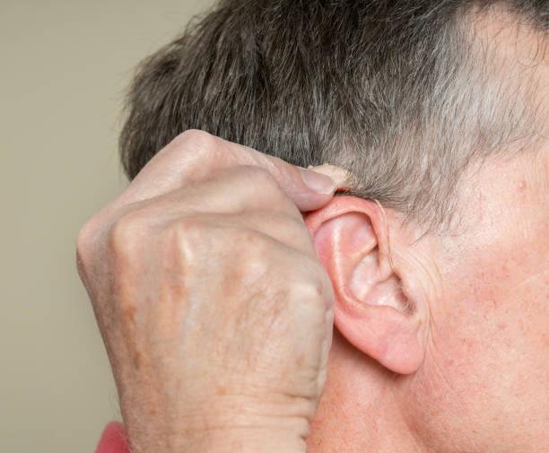 istock Close up of a tiny modern hearing aid behind ear 876671448