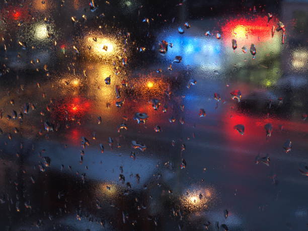 istock Abstract rain drops on window with night traffic lights. 876674514