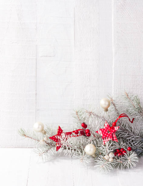 istock Fir branch with Christmas decorations on white rustic wooden background with copy space for text. 876674572