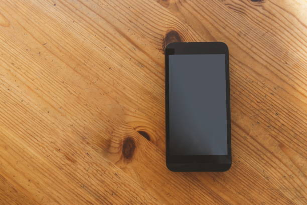 istock Smartphone and fidget spinner on wooden table. 876674976