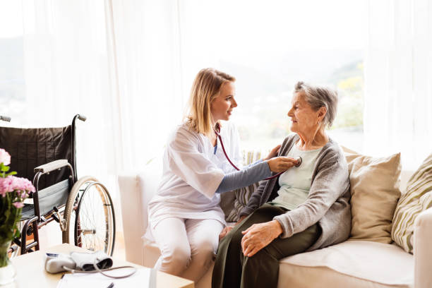 health visitor and a senior woman during home visit. - home health nurse imagens e fotografias de stock