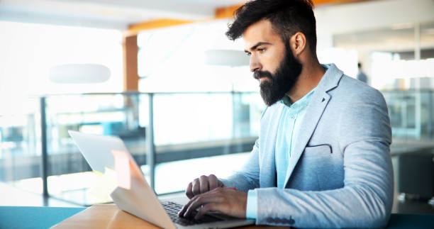 istock Professional handsome businessman using laptop at workplace 876679356
