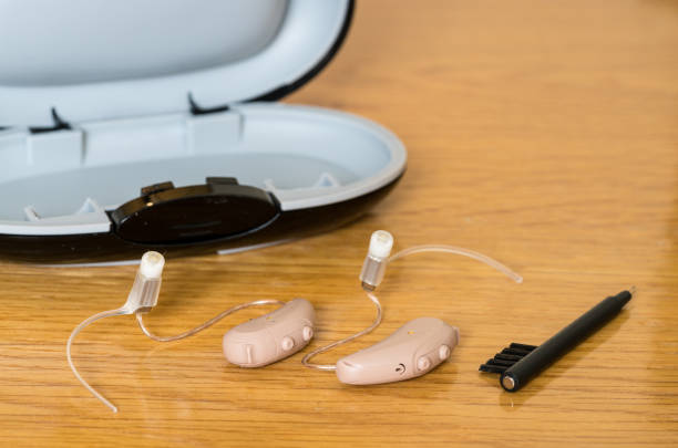 nahaufnahme von ein paar winzige modernes hörgerät auf nachttisch - hearing aid audiologist audiology small stock-fotos und bilder