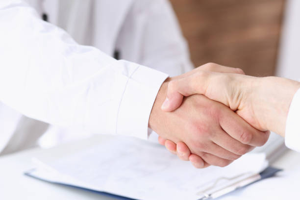 istock Doctor shake hand as hello with patient 876693364