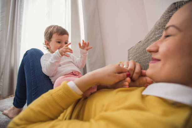 istock Young mother playing with baby daughter 876696788