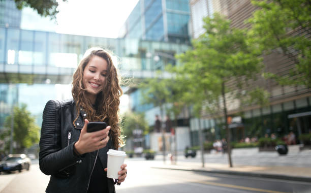 mujer sonriente con teléfono móvil. - contemporary elegance telephone urban scene fotografías e imágenes de stock