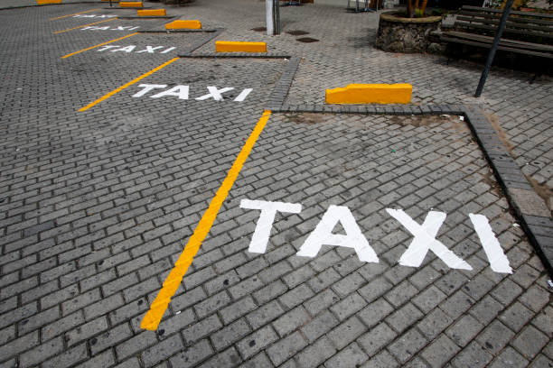 Signposted taxi stand in the street Taxi sign posted in public way with white paint dirigir stock pictures, royalty-free photos & images