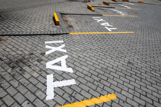 Signposted taxi stand in the street Taxi sign posted in public way with white paint dirigir stock pictures, royalty-free photos & images