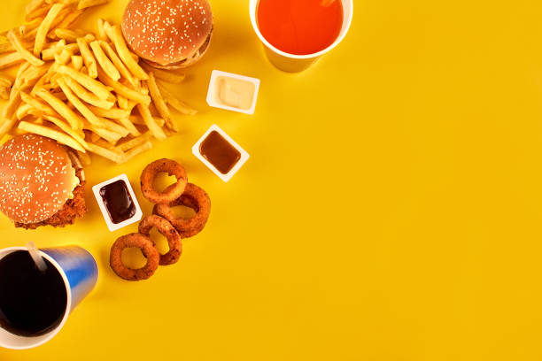 istock Fast food concept with greasy fried restaurant take out as onion rings, burger, fried chicken and french fries as a symbol of diet temptation resulting in unhealthy nutrition 876704448