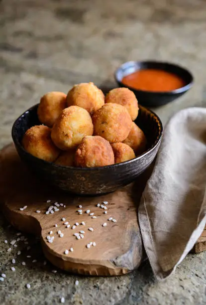 Arancini - traditional Italian deep fried rice balls with meat and cheese, served with tomato sauce
