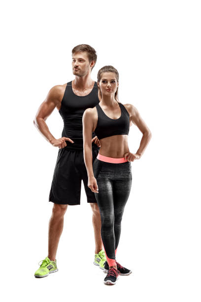 Sport, fitness, workout concept. Fit couple, strong muscular man and slim woman posing on a white background Sport, fitness, workout concept. Fit couple, strong muscular man and slim woman posing on a white background. A man and a woman in sportswear man muscular chest stock pictures, royalty-free photos & images