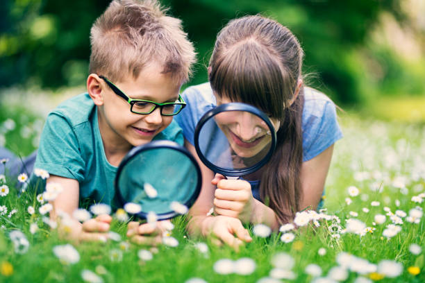 istock Brother and sister having fun observing grass 876721642