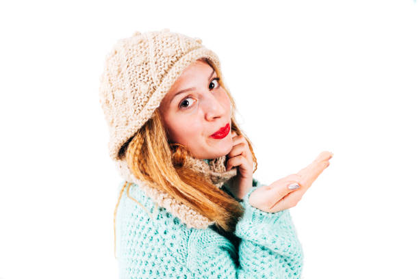 Closeup of a beautiful young woman wearing warm knitted clothes while posing at studio- isolated on white.