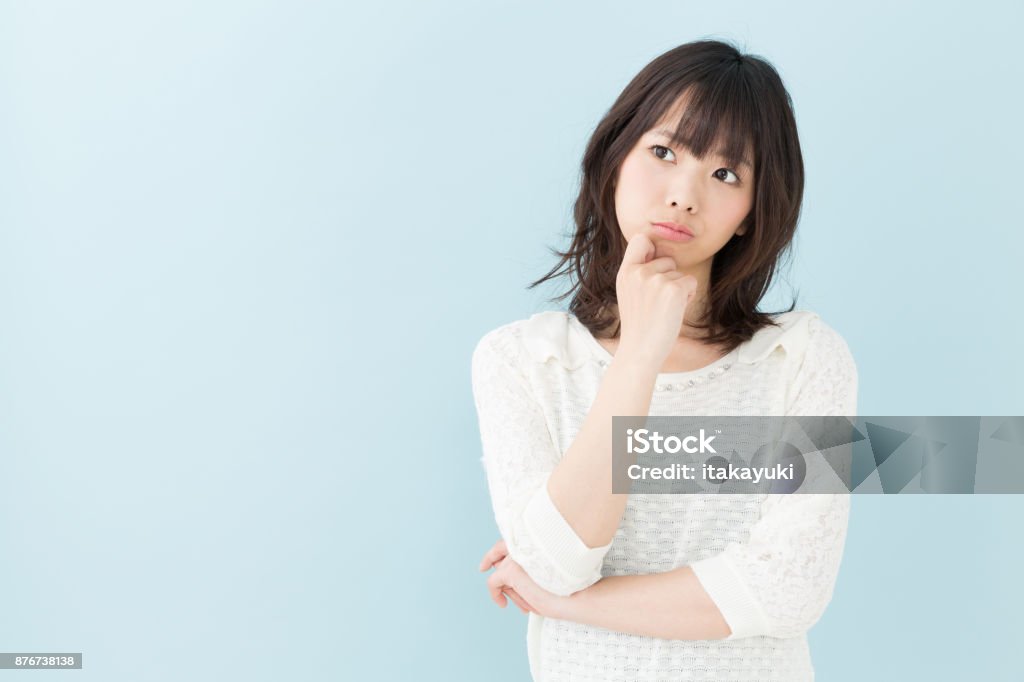 portrait of attractive asian woman isolated on blue background Worried Stock Photo