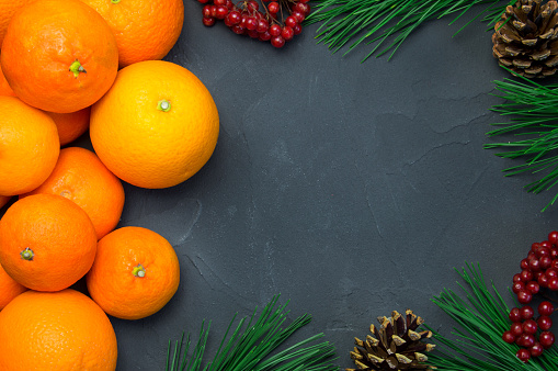Orange and tangerine with branch christmas tree and ashberry on black concrete background