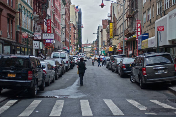 New York, USA - June 20, 2012: Tourists walks through a Chinatown street filled with posters and advertisements for various bars and restaurants