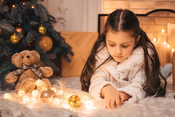 istock Sad little girl near Christmas tree 876751484