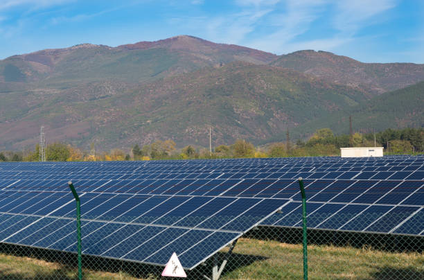 istock Solar panels with blue sky and mountains in the background. 876763106
