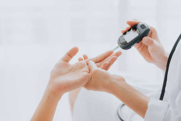 médico utiliza glucosmeter con la mano del paciente - diabetes fotografías e imágenes de stock