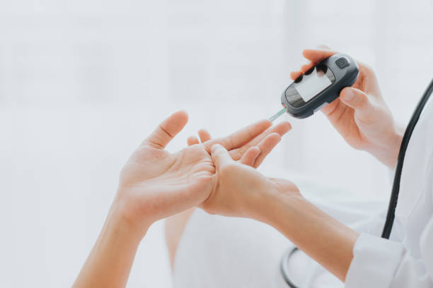 Doctor use glucosmeter with patient hand Doctor use glucosmeter checking blood sugar level from patient hand diabetes stock pictures, royalty-free photos & images