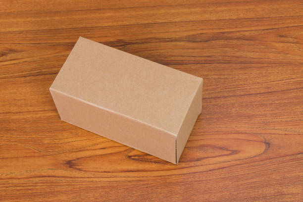 istock Empty closed brown cardboard box for mock up on the wooden table with copy space. 876774798