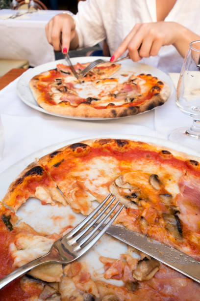 Table setting at an Italian pizzeria with 2 pizzas.