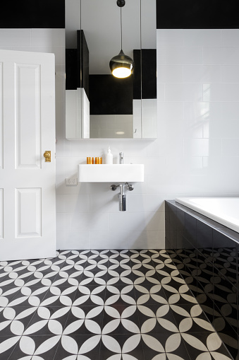 Luxury monochrome designer bathroom renovation with patterned floor tiles