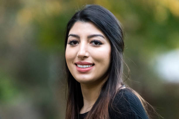 Smiling young woman Smiling middle eastern or hispanic young woman posing with her arms crossed iranian ethnicity stock pictures, royalty-free photos & images