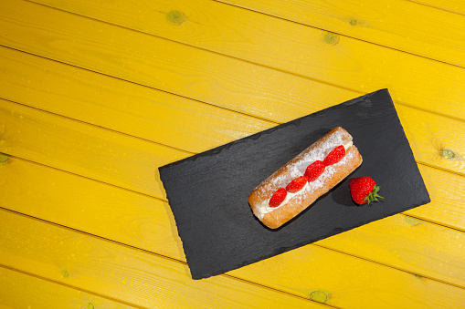 Strawberry cake on yellow table. Bright colorful food art image. Colourful sugary doughut. Delicious donut vibrant summer color dessert.