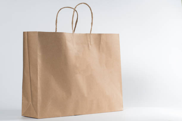 пустой коричневый бумажный торговый мешок изолирован на белом фоне. - paper bag bag brown handle стоковые фото и изображения