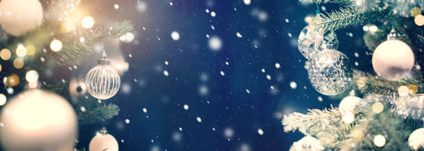 istock Closeup of silver bauble hanging from a decorated Christmas tree. 876822544