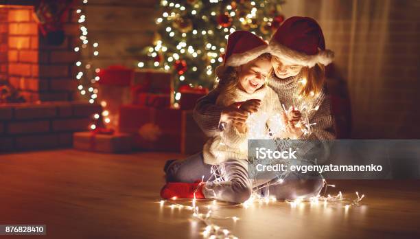 Frohe Weihnachten Mutter Und Kind Tochter Mit Glühenden Girlande In Der Nähe Von Baum Stockfoto und mehr Bilder von Weihnachten