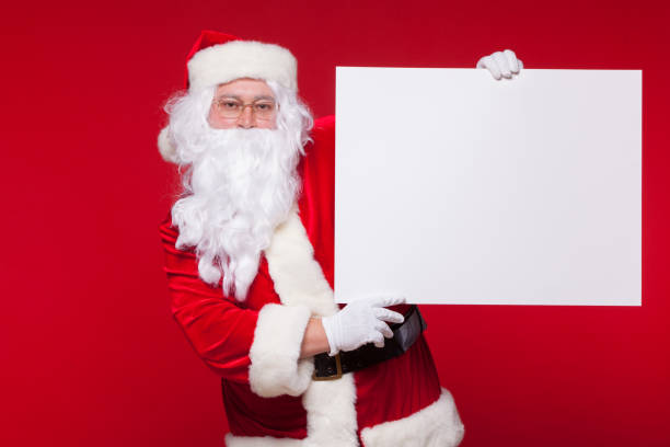 istock Santa Claus pointing in blank advertisement banner isolated on red background with copy space 876828696