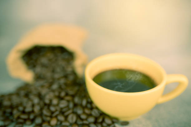 coffee beans in bag and yellow coffee cup
