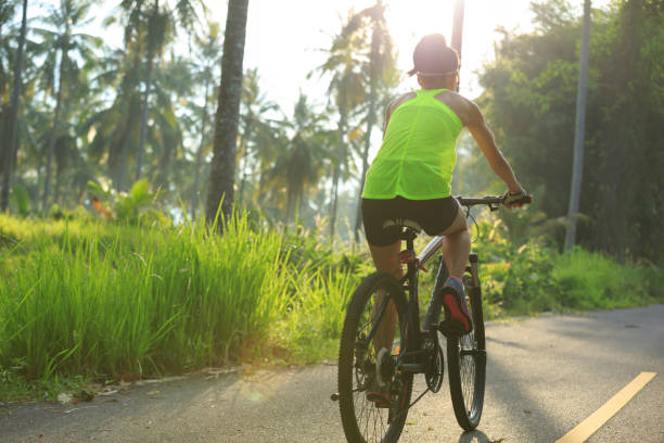 istock Young  woman cyclist cycling on tropical forest trail 876829092