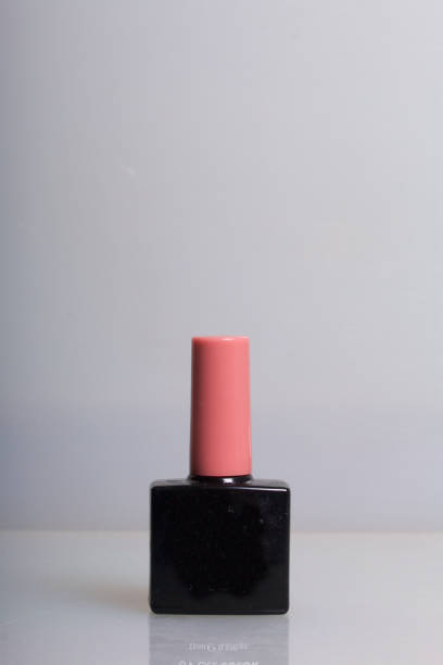 istock Nail coating with gel-varnish. Gel-lacquer in black bottles stands on a white surface. 876829094