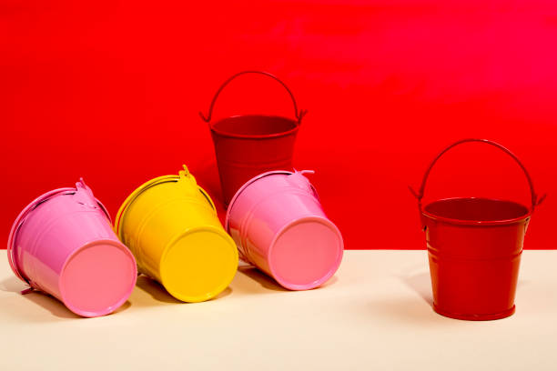 istock Pink, red and yellow buckets on a yellow background 876831772